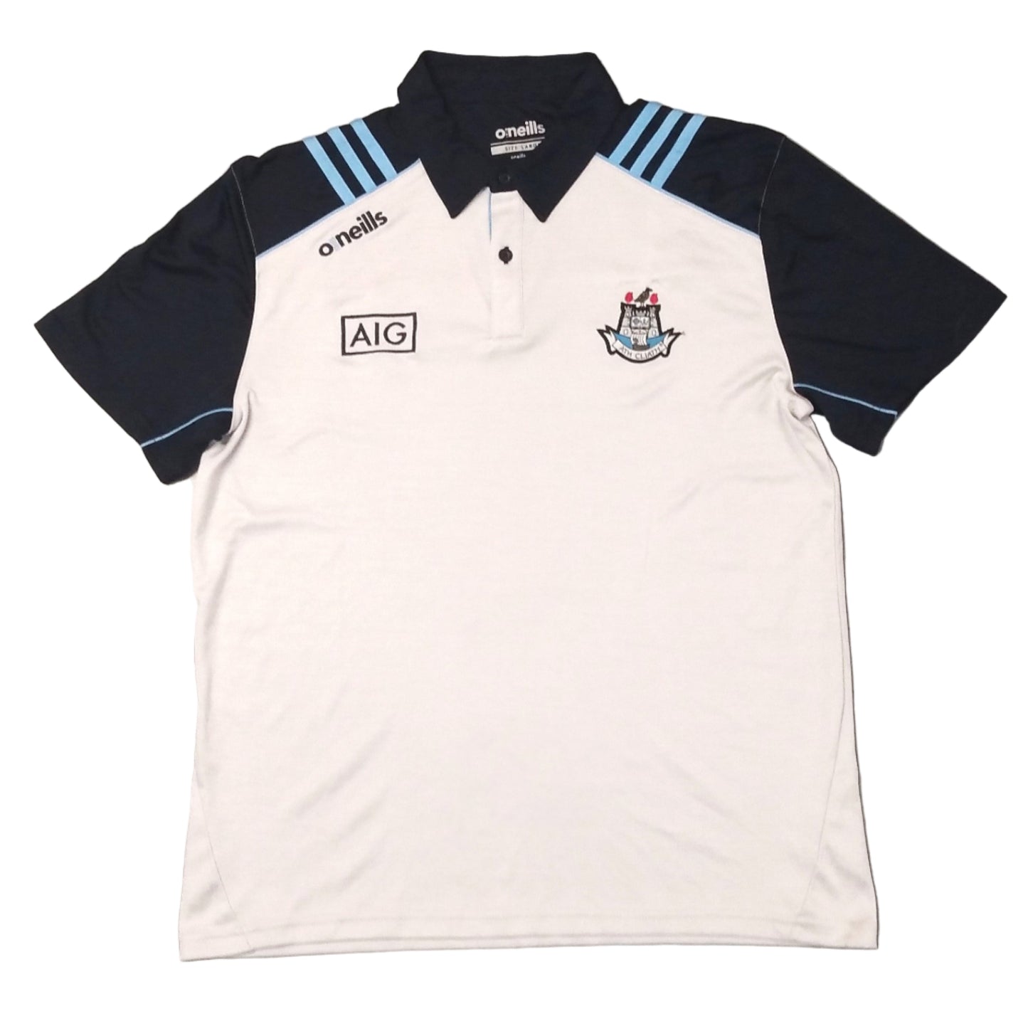 A white polo shirt with navy and blue details, featuring a logo on the chest and a collar. The shirt is laid flat on a grey surface.