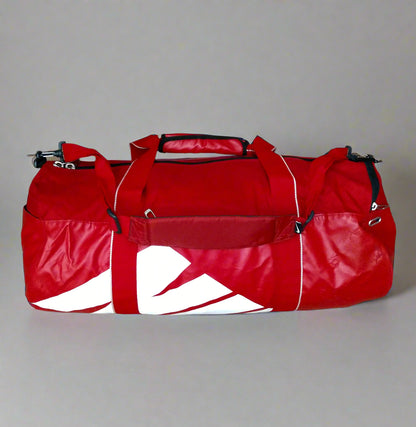 Red duffel bag with a white logo on a beige floor.
