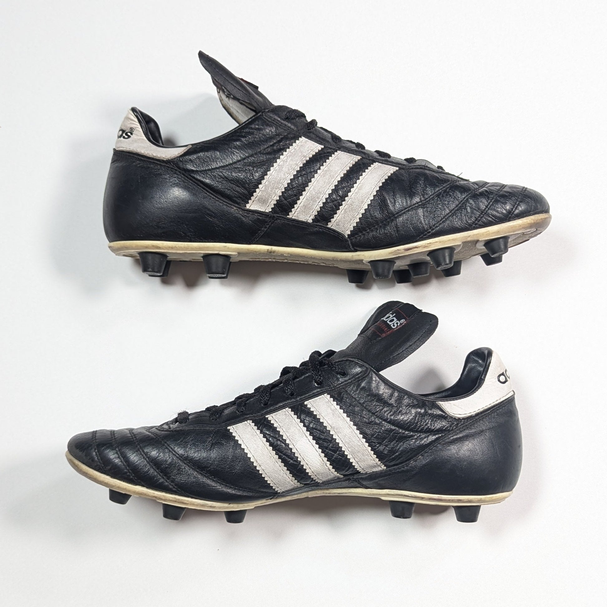 Pair of black Adidas soccer cleats on a white background