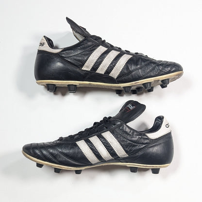 Pair of black Adidas soccer cleats on a white background