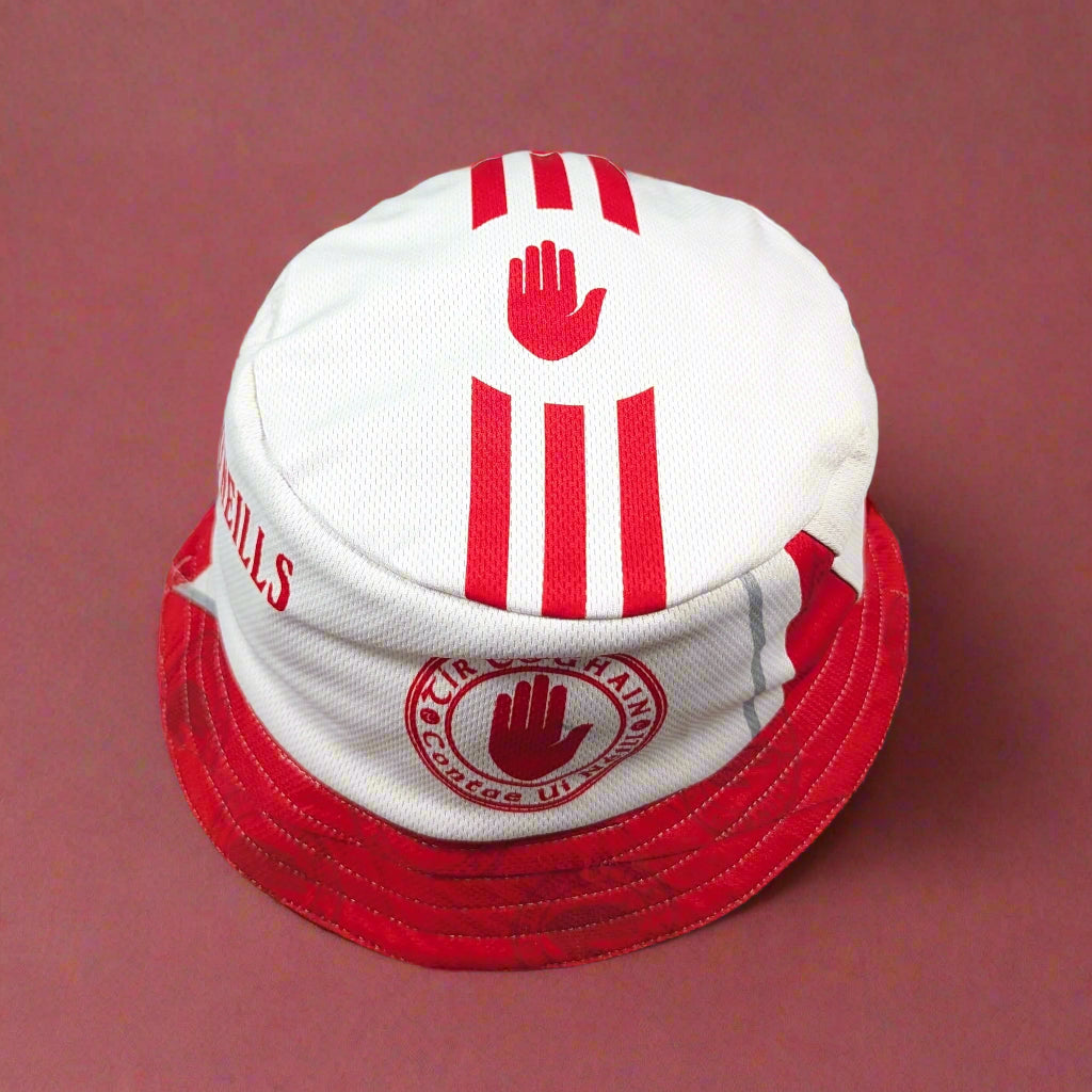 White and red bucket hat with branding on a light gray background